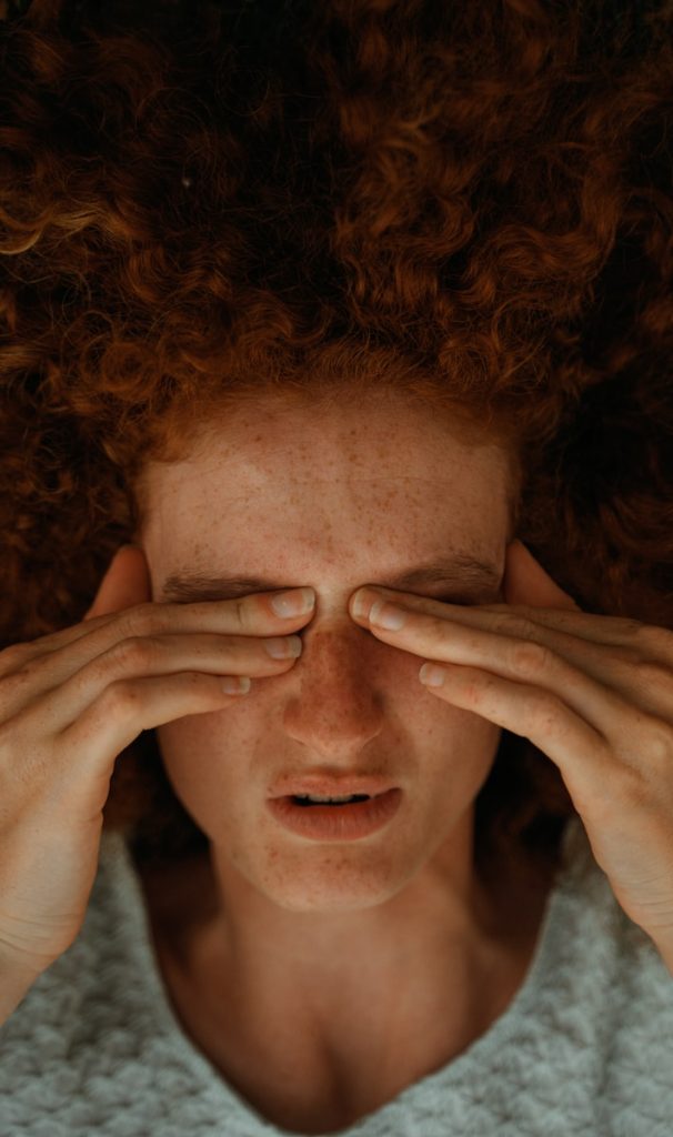 a woman with red hair covering her eyes