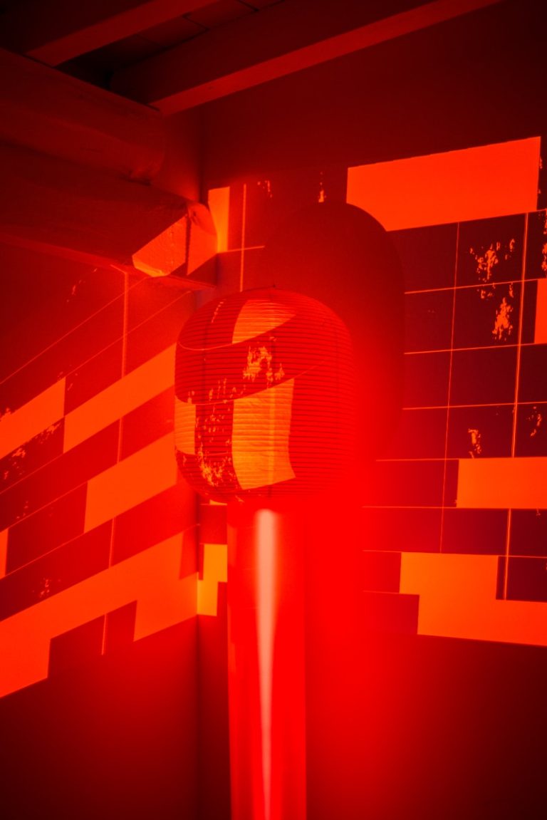 a red and black photo of a clock on a pole